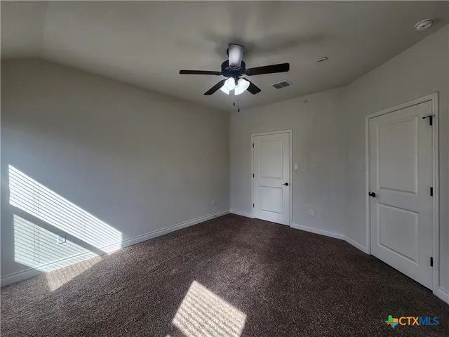 a view of empty room with ceiling fan