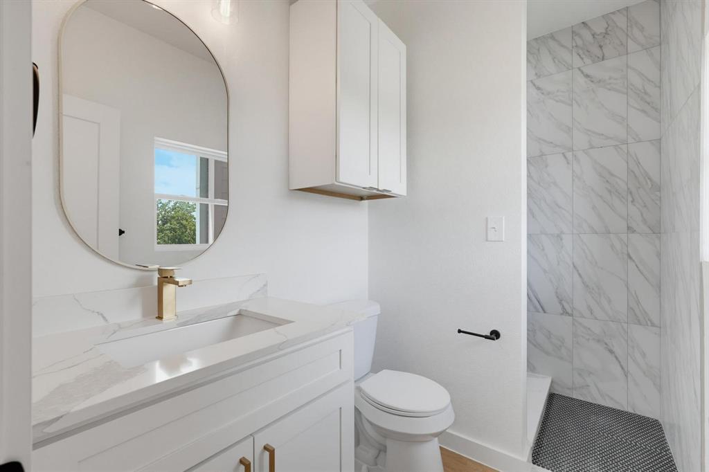 504 South O Connor Road Irving, TX 75060 - Photo 20 of 23 Bathroom featuring a vanity with an integrated sink, gold-tone faucet, and white countertop