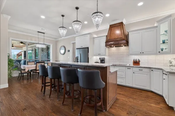 a kitchen with stainless steel appliances kitchen island granite countertop a table chairs and a stove