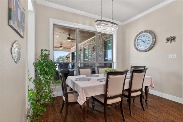 a view of a dining room with furniture a chandelier and wooden floor