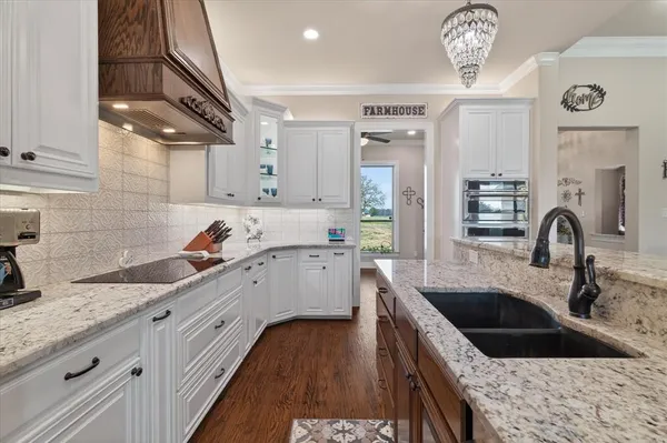 a kitchen with granite countertop a sink stainless steel appliances and cabinets