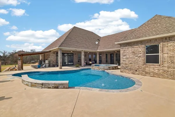 a view of a house with swimming pool and a yard