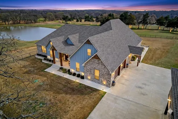 an aerial view of a house with outdoor space and lake view