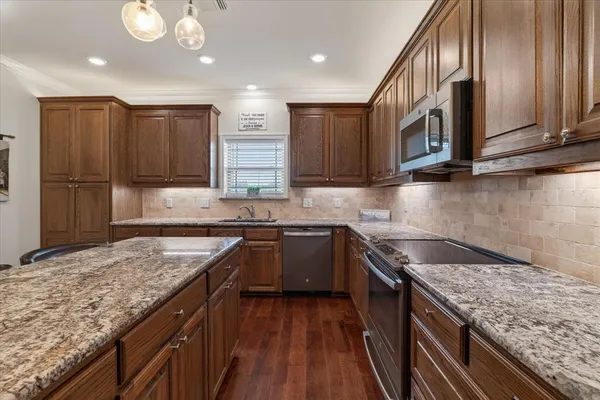 a kitchen with stainless steel appliances granite countertop a sink stove and cabinets