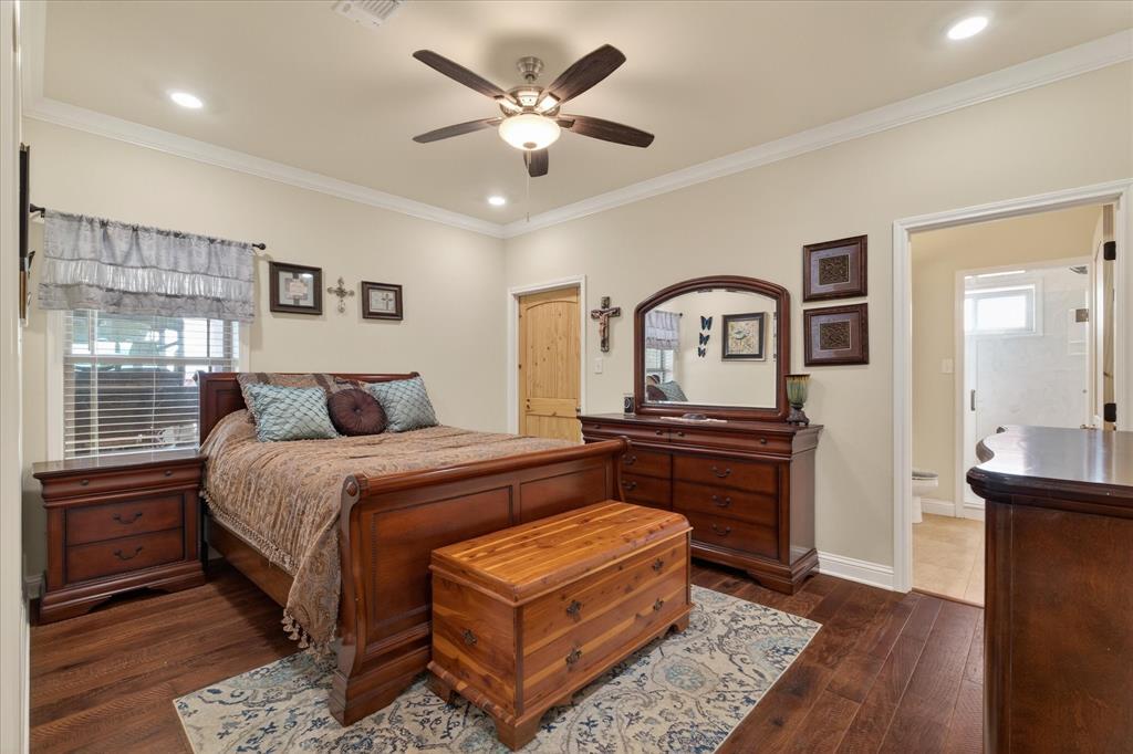 790 Bones Chapel Road Whitesboro, TX 76273 - Photo 35 of 40 a bedroom with a bed a dresser and potted plants