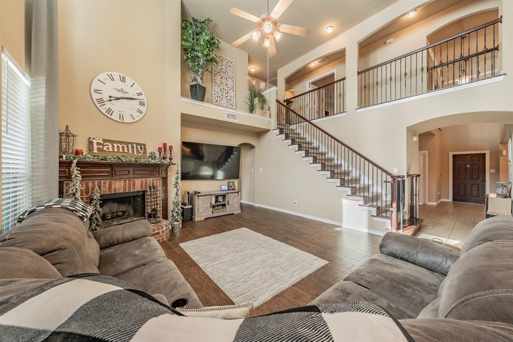 5112 Leeray Road Fort Worth, TX 76244 - Photo 15 of 34 a living room with furniture a fireplace and a chandelier