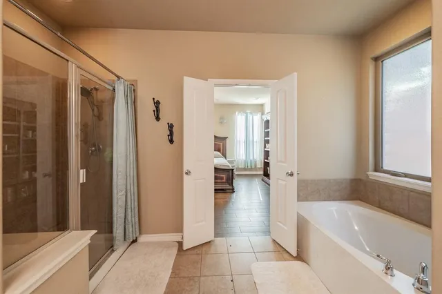 a bathroom with a tub shower and sink