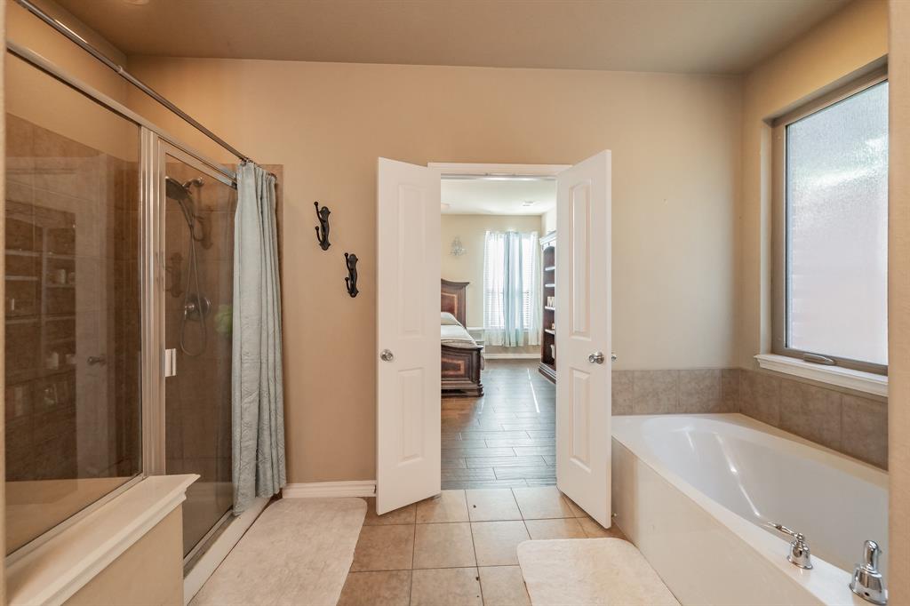 5112 Leeray Road Fort Worth, TX 76244 - Photo 19 of 34 a bathroom with a tub shower and sink