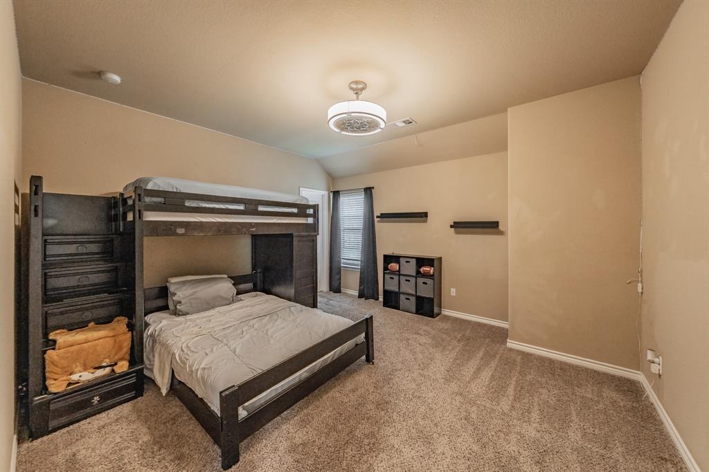 5112 Leeray Road Fort Worth, TX 76244 - Photo 23 of 34 a bedroom with a bed and a chandelier