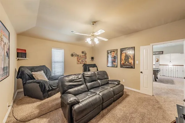 a living room with furniture and a ceiling fan