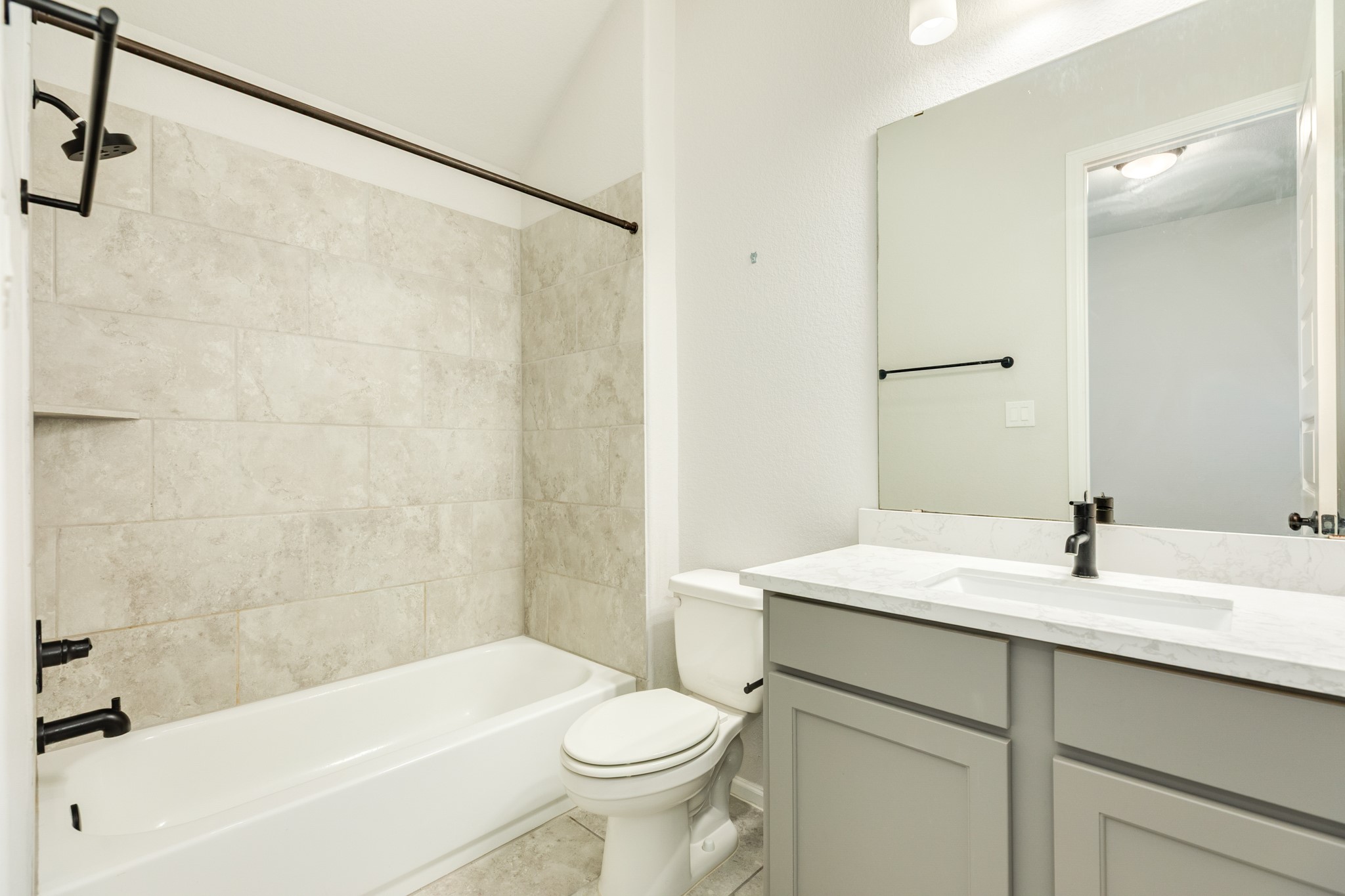 10115 Stride Court Rosharon, TX 77583 - Photo 20 of 40 Guest suite bathroom featuring a tub-shower combination, elegant quartz countertops, and excellent lighting.