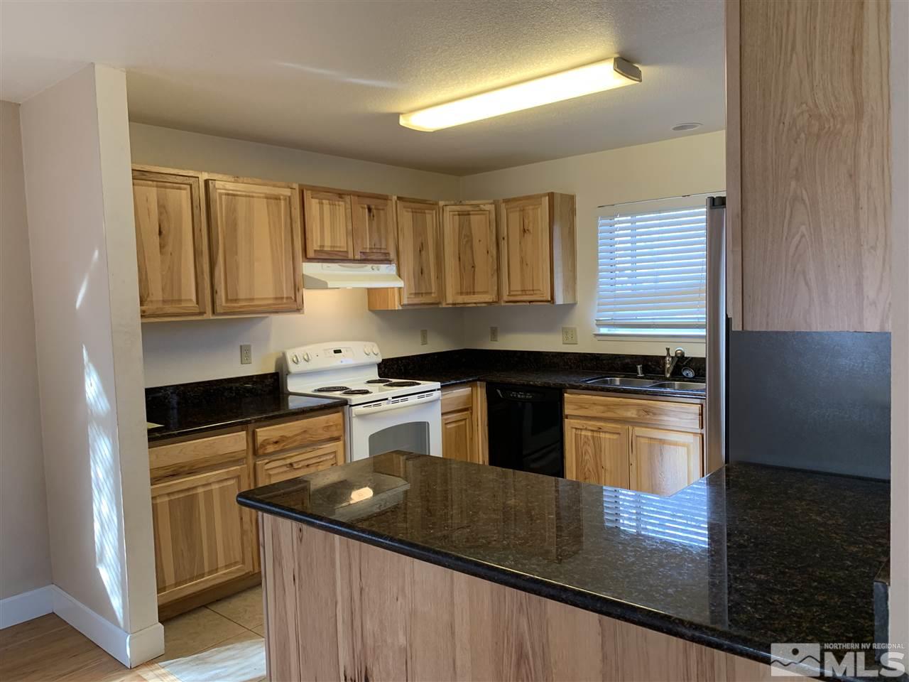 100 Silverstone Place Reno, NV 89512 - Photo 5 of 17 a kitchen with granite countertop a sink a stove and cabinets