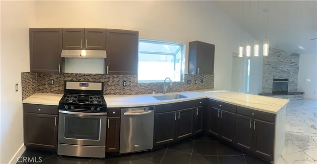a kitchen with granite countertop a stove and a sink