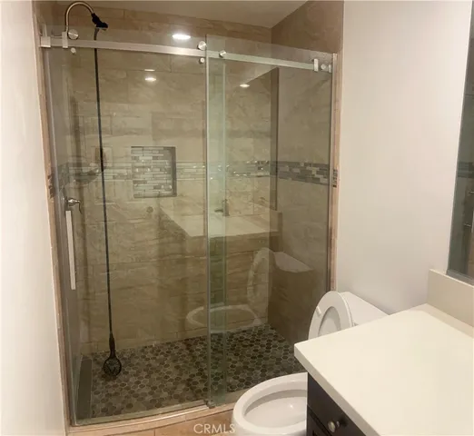 a bathroom with a shower a toilet and a sink