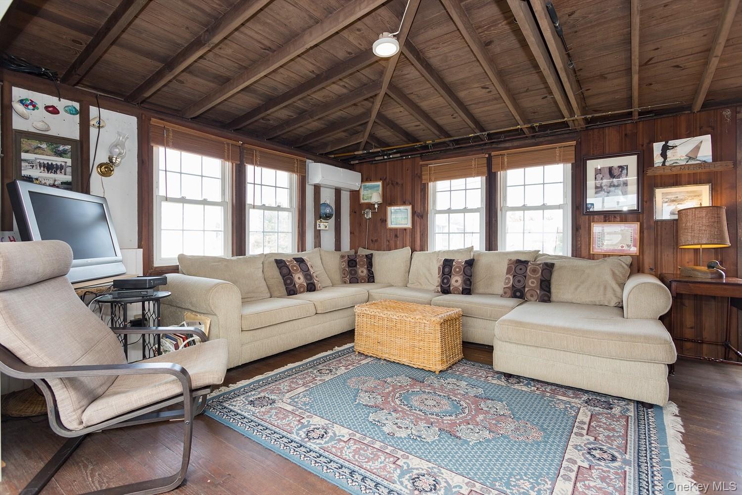 39 Point Road Westhampton Beach, NY 11978 - Photo 7 of 15 a living room with furniture a wooden floor and a chandelier