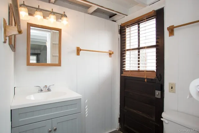 a bathroom with a sink a mirror and a window