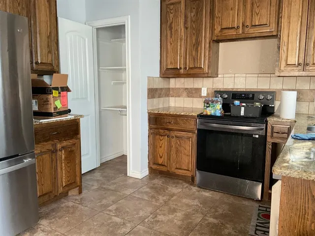 a kitchen with granite countertop a sink stove and cabinets