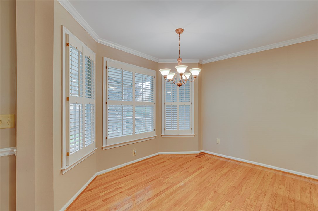 302 Wild Rice Drive Simpsonville, SC 29681 - Photo 9 of 44 Rich hardwood flooring complements a classic bay window alcove trimmed with plantation shutters.