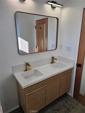 a bathroom with a sink a toilet and mirror