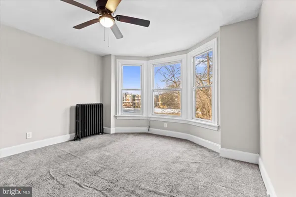 an empty room with closet and windows