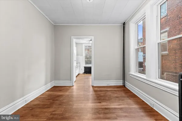 a view of empty room with wooden floor and windows