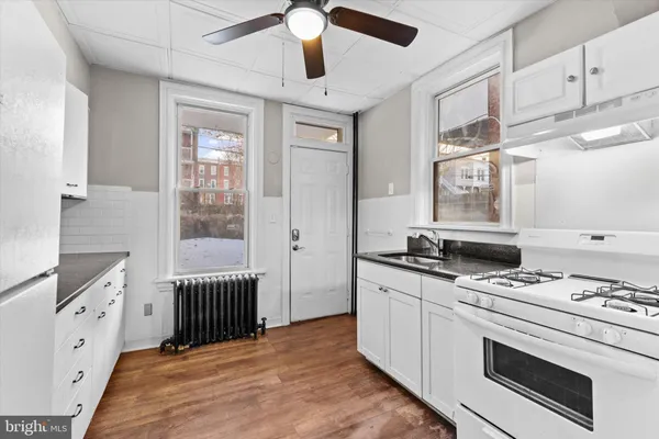 a kitchen with granite countertop white cabinets and stainless steel appliances