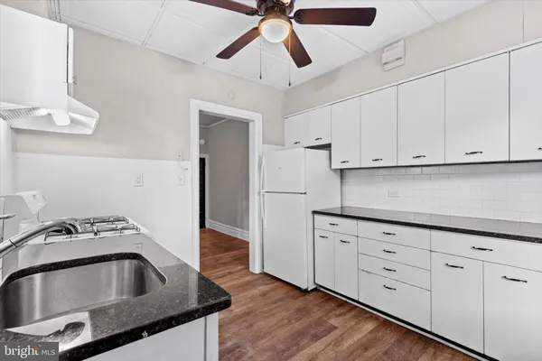 a kitchen with cabinets a sink and white stainless steel appliances