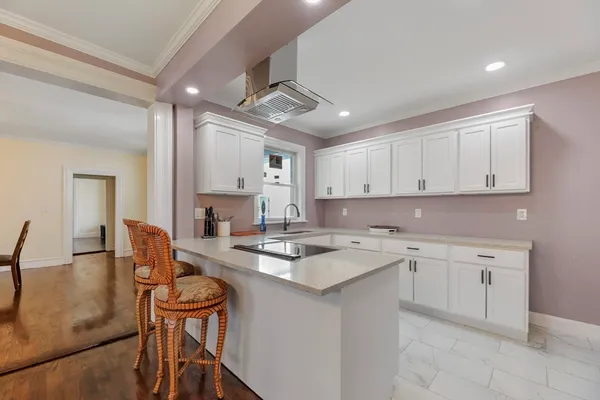 a kitchen with a stove a sink a dining table and chairs