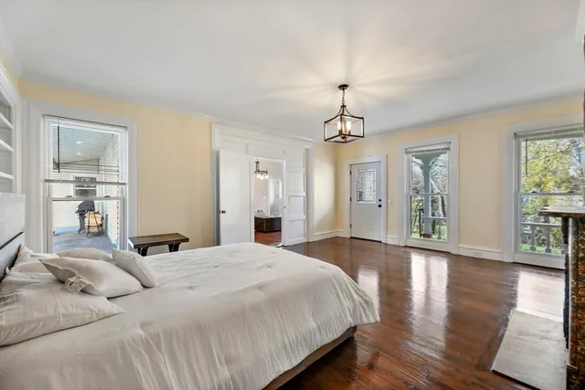 a bedroom with a large bed and wooden floor