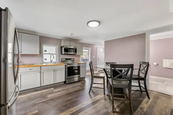 a kitchen with a table chairs microwave and cabinets