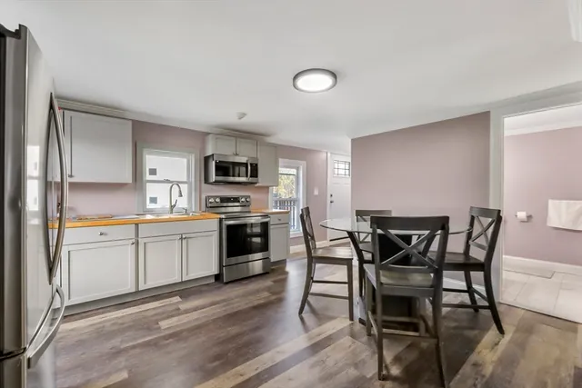 a kitchen with a table chairs microwave and cabinets
