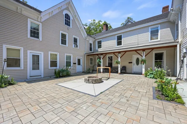 a patio with a table and chairs and potted plants