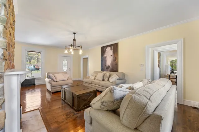 a living room with furniture chandelier and a window