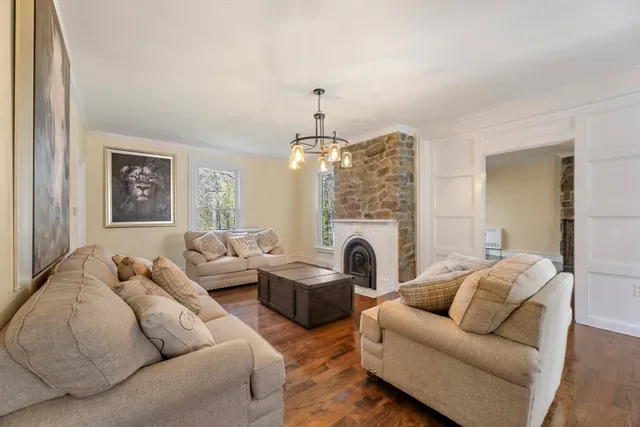 a living room with furniture a fireplace and a chandelier