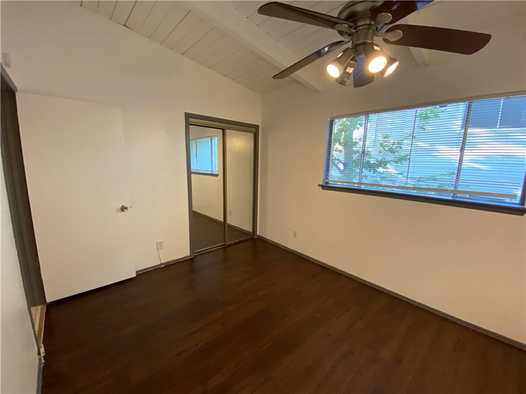 2413 Leon Street, Unit 102 Austin, TX 78705 - Photo 18 of 22 an empty room with wooden floor chandelier fan and windows