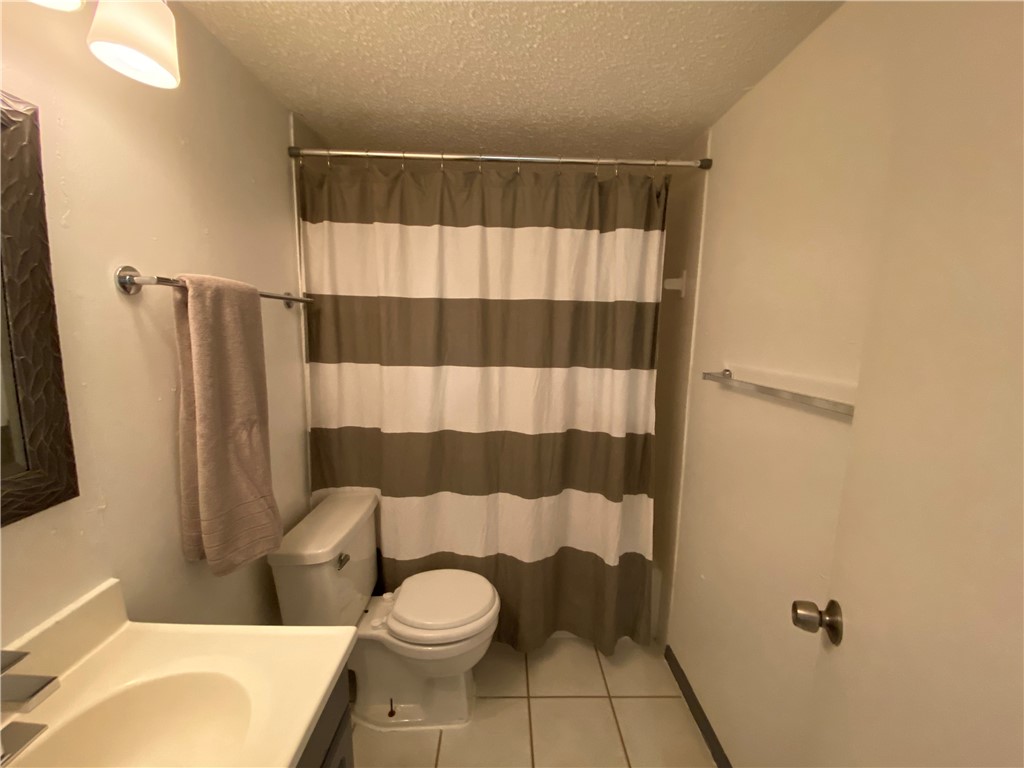 2413 Leon Street, Unit 102 Austin, TX 78705 - Photo 19 of 22 a bathroom with a toilet and a shower curtain