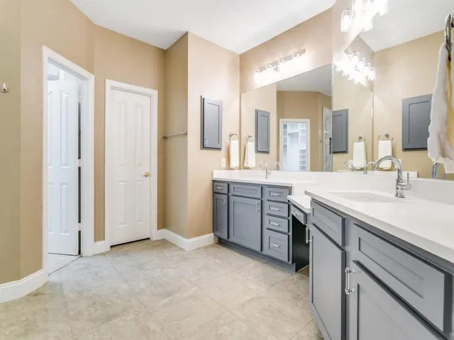 a spacious bathroom with a granite countertop sink a mirror and a shower