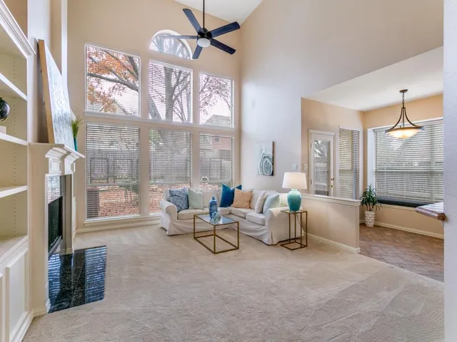 a living room with furniture a fireplace and a floor to ceiling window