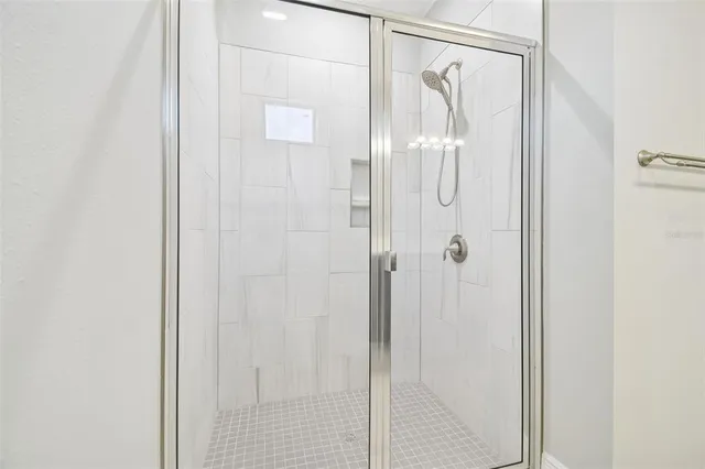 a view of an empty room with a window and kitchen view