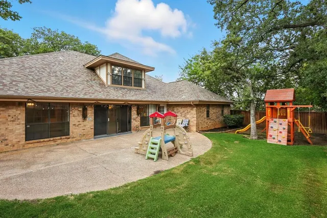 an aerial view of residential houses with outdoor space and trees