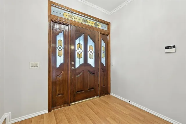 a view of an empty room with wooden floor fireplace and a window