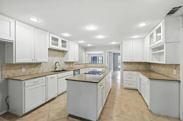 a kitchen with granite countertop a sink a stove and cabinets