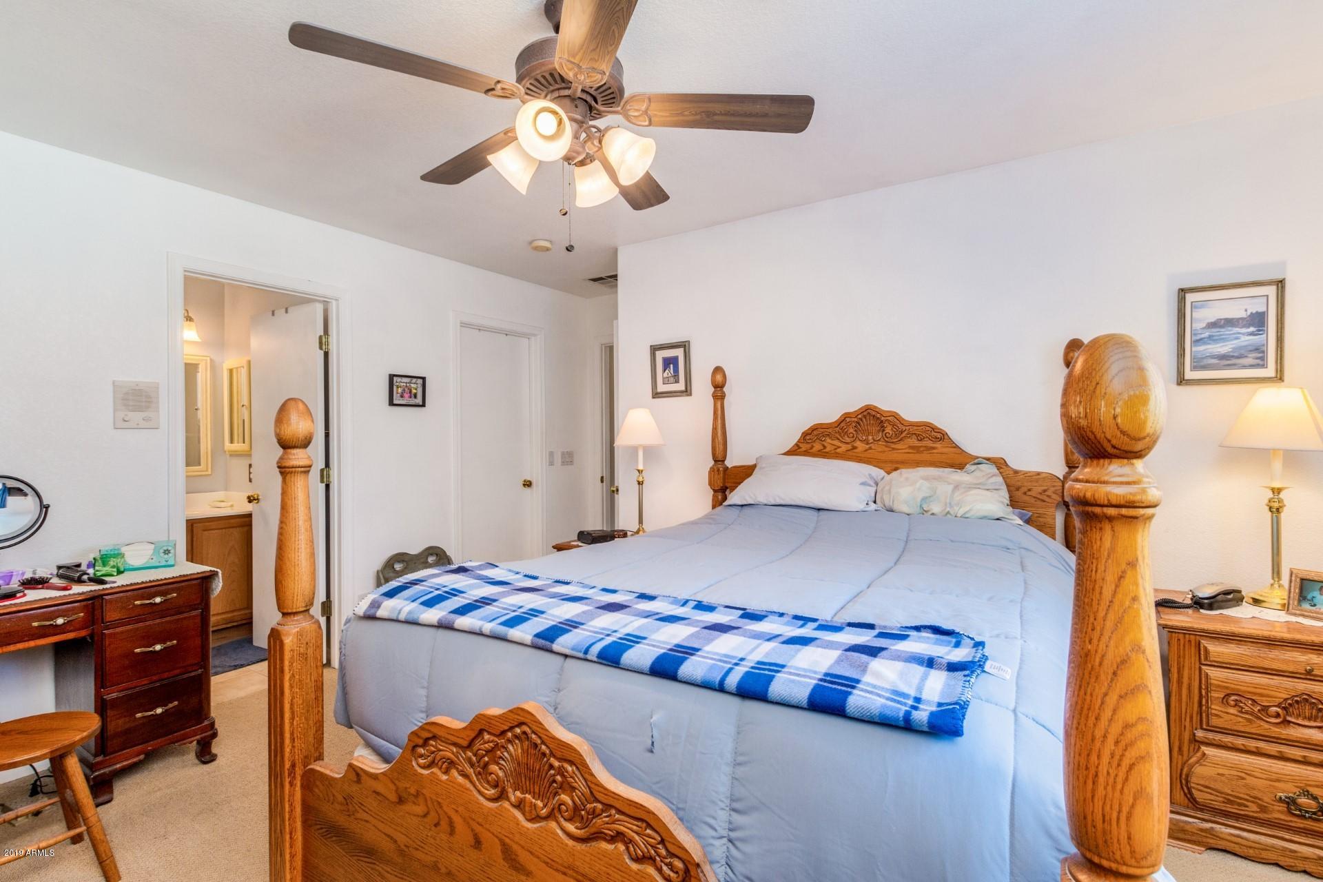 15033 West Calavar Road Surprise, AZ 85379 - Photo 16 of 21 a bedroom with a bed and a chandelier