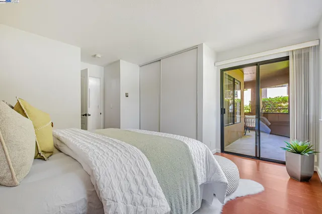 a bedroom with a bed and large windows