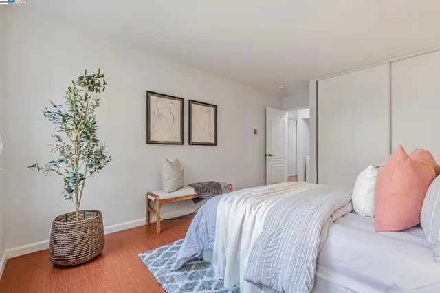 a bedroom with bed and a potted plant