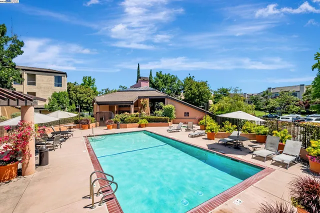 a view of a swimming pool with lounge chairs in patio