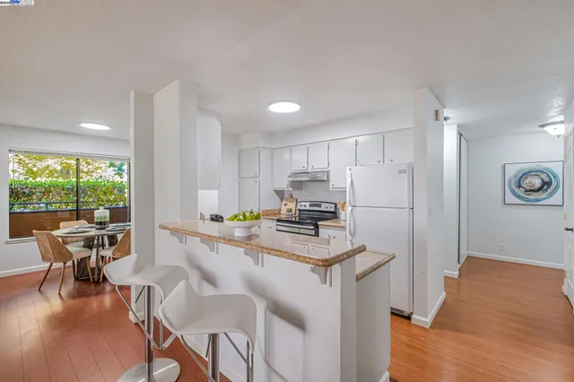 a kitchen with a table chairs refrigerator and cabinets