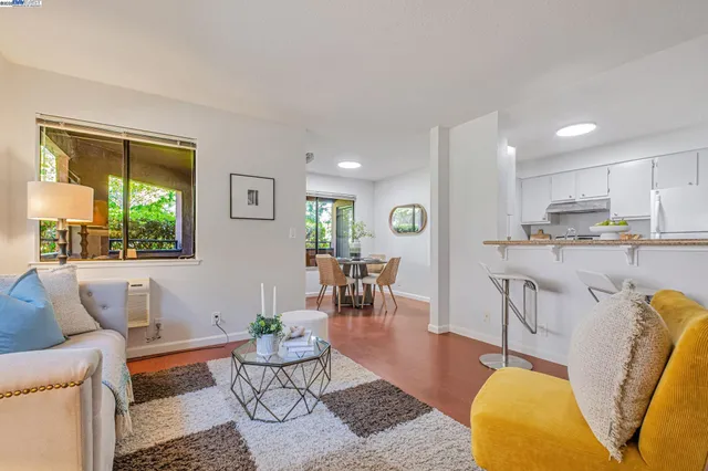 a living room with furniture and a dining table with wooden floor
