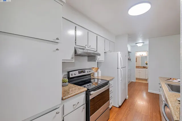 a kitchen with cabinets and wooden floor