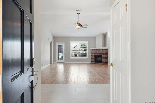 a view of an empty room with a fireplace and a window